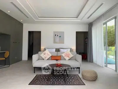 Modern living room with elegant decor and large windows opening to a lush garden view.