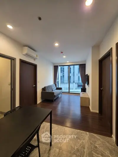 Modern living room with sleek design and large windows offering ample natural light.