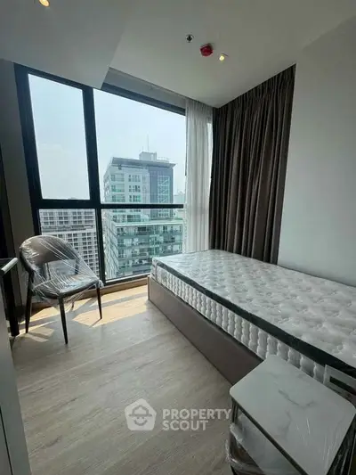 Modern bedroom with city view, featuring a single bed and floor-to-ceiling windows.