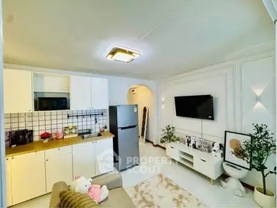 Modern living room with open kitchen, featuring sleek appliances and stylish decor.