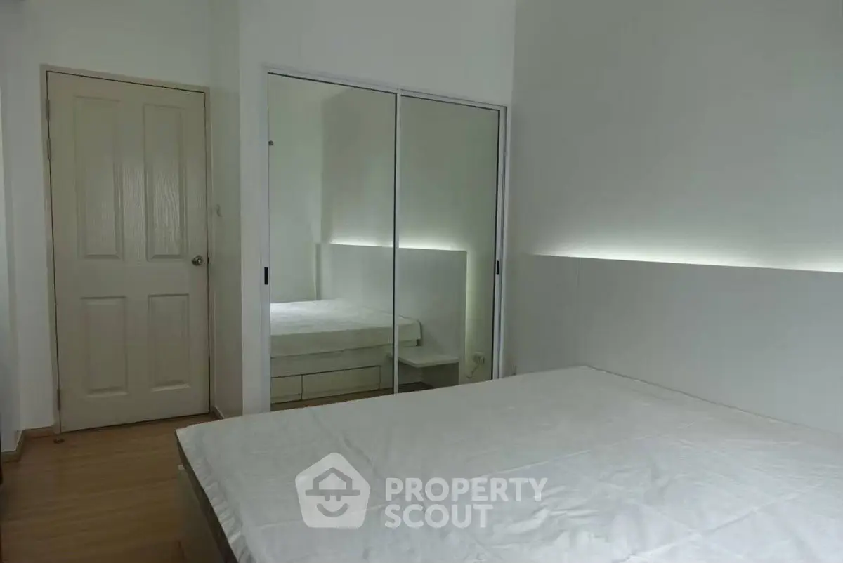 Minimalist bedroom with mirrored closet and modern lighting