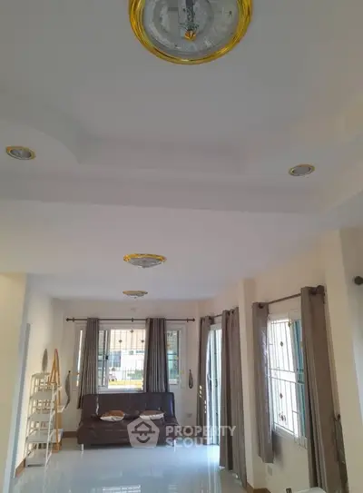 Spacious living room with modern ceiling design and large windows for natural light.