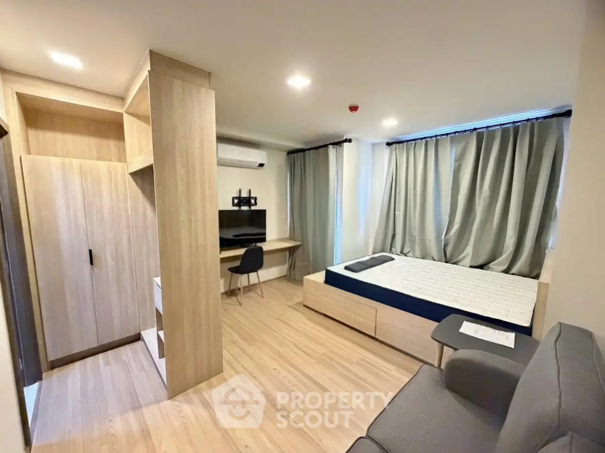 Modern bedroom with stylish furniture and natural light, perfect for urban living.