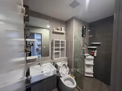 Modern bathroom with glass shower and sleek fixtures in contemporary apartment.