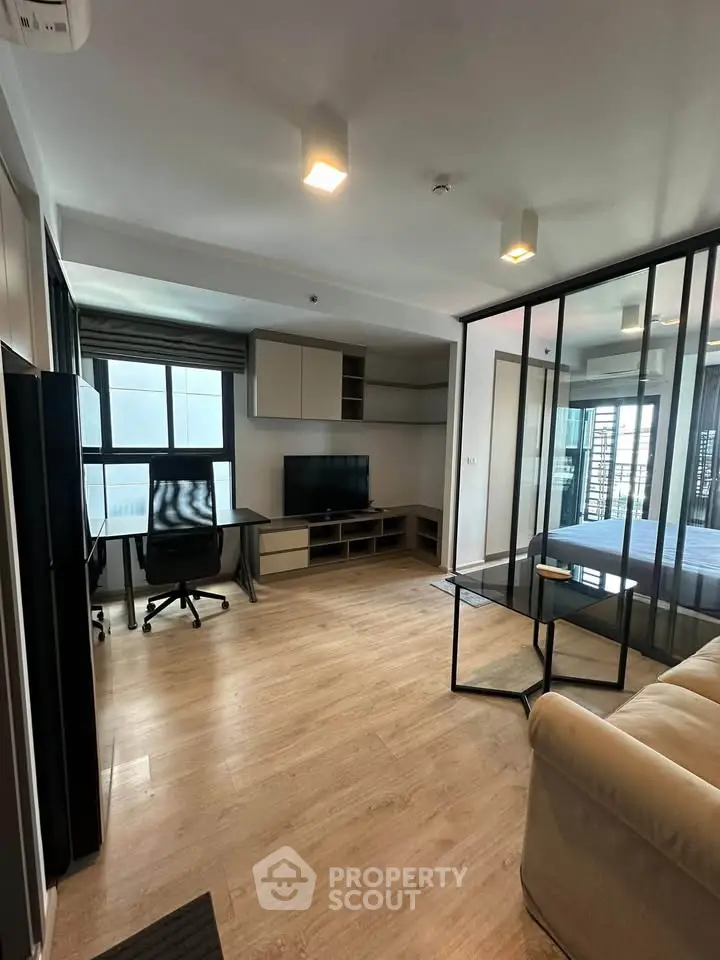 Modern living room with glass partition and study area in stylish apartment