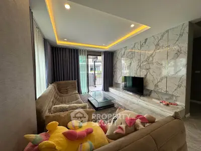 Luxurious living room with plush sofas, marble wall, and modern lighting in a stylish home.