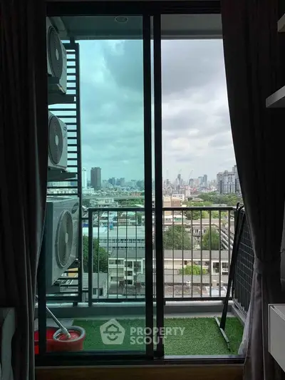 Stunning city view from a cozy balcony with air conditioning units, perfect for urban living.