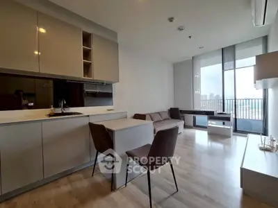 Modern open-plan living room with sleek kitchen and city view balcony.