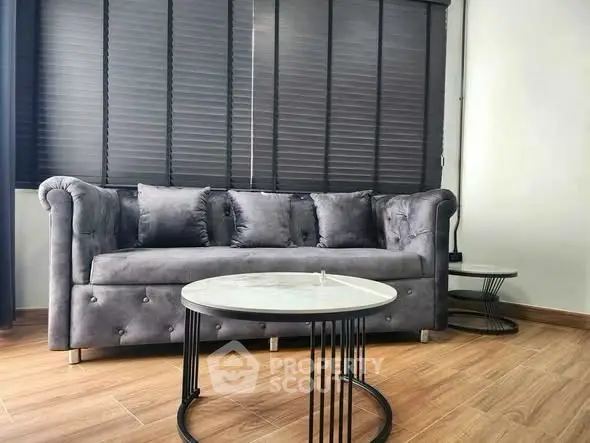 Stylish living room with elegant gray sofa and modern round coffee tables, perfect for contemporary interiors.