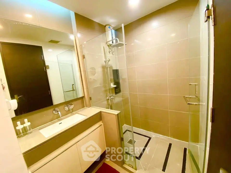 Modern bathroom with glass shower and sleek vanity in luxury apartment