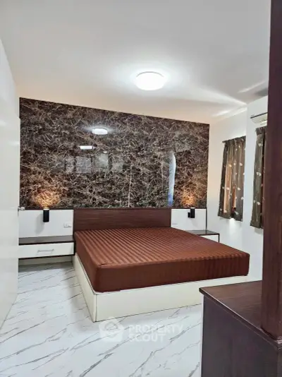 Modern bedroom with marble accent wall and sleek furnishings