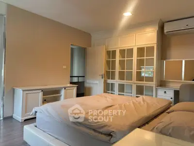 Spacious bedroom with elegant built-in wardrobe and air conditioning, perfect for comfort and style.