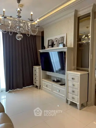Elegant living room with chandelier and modern TV setup in luxury apartment