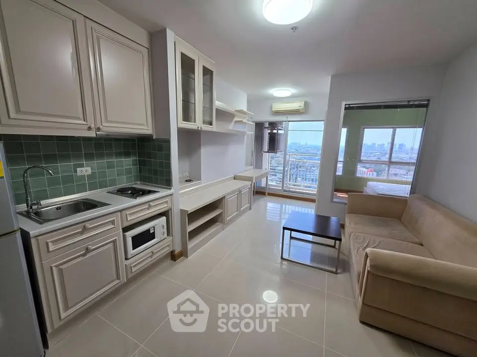 Modern open-layout living room with kitchen and city view balcony in high-rise apartment.