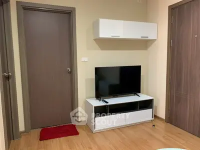 Modern living room with sleek TV stand and wall-mounted cabinet, featuring wooden flooring and neutral tones.