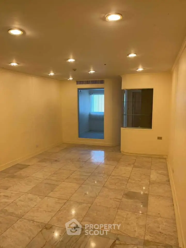 Spacious living room with marble flooring and recessed lighting