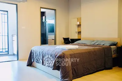 Spacious bedroom with modern decor and ensuite bathroom in a stylish apartment.