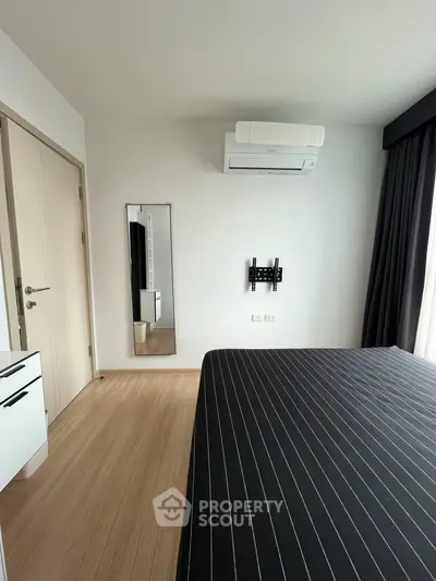 Modern bedroom with air conditioning and sleek black bedding