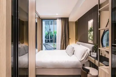 Modern bedroom with elegant decor and garden view, featuring a cozy bed and stylish furnishings.