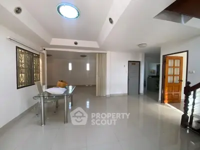 Spacious modern living room with sleek tile flooring and abundant natural light.