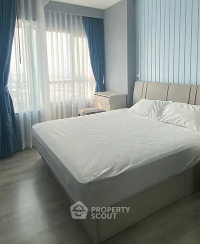 Bright and cozy bedroom with large window and modern furnishings