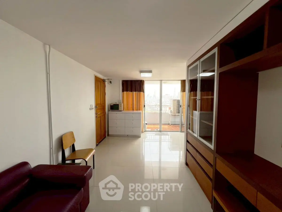 Spacious living room with modern furniture and balcony access in urban apartment.