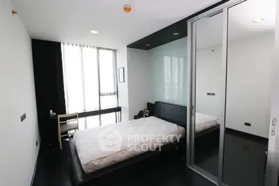 Modern bedroom with sleek black flooring and minimalist design