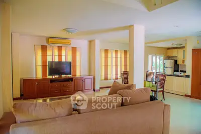 Spacious living room with modern furniture and open kitchen layout in a bright apartment.