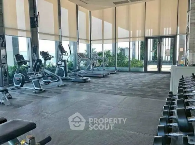 Spacious modern gym with state-of-the-art equipment and floor-to-ceiling windows.