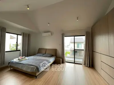 Spacious bedroom with modern decor and balcony access in a bright, airy home.