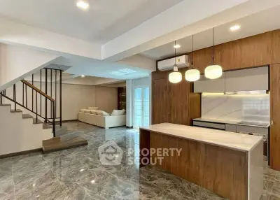Spacious modern living room with open kitchen and elegant staircase
