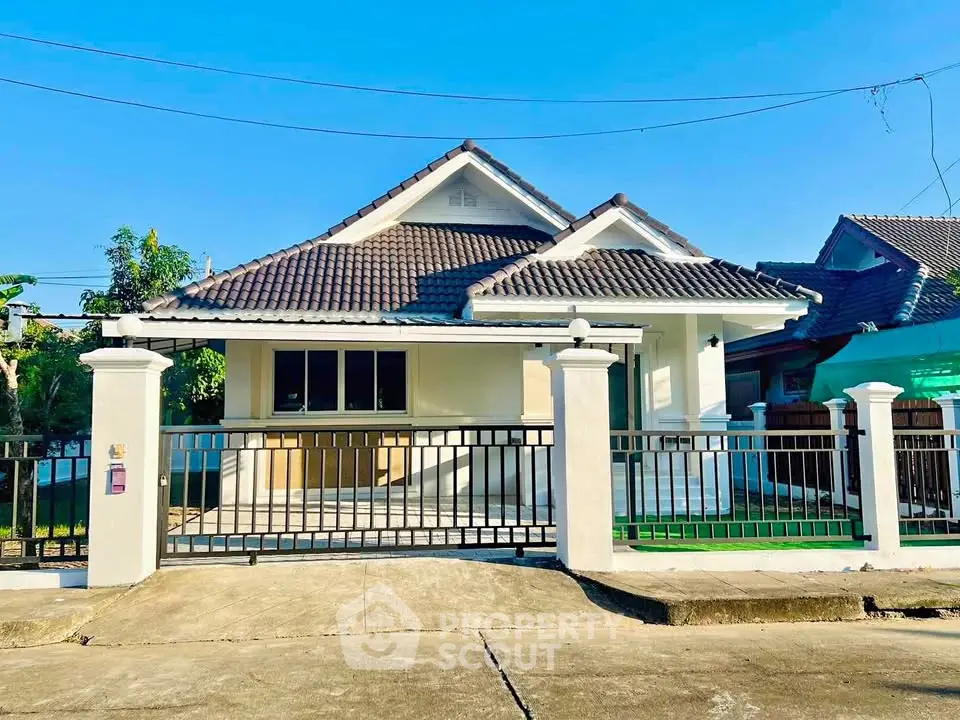 Charming single-story house with tiled roof and gated entrance in a serene neighborhood.