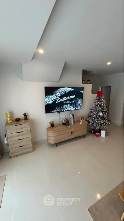 Modern living room with Christmas tree and wall-mounted TV
