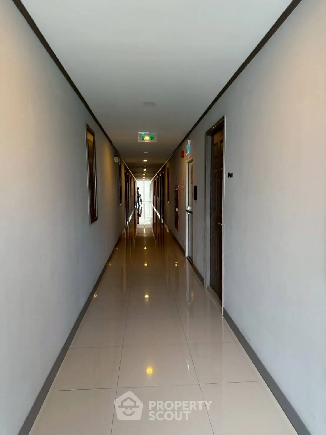 Sleek modern corridor with polished floors and ambient lighting in a residential building.
