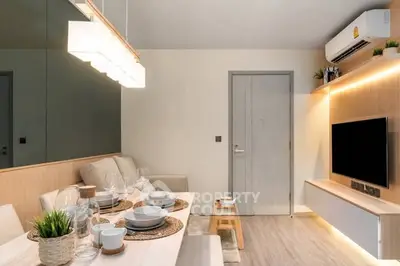 Modern living room with stylish decor and dining area, featuring sleek furniture and ambient lighting.