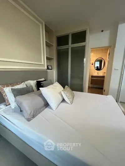 Modern bedroom with stylish decor and ensuite bathroom, featuring a cozy bed and ample storage space.
