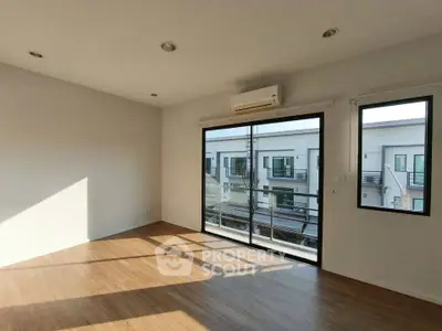 Spacious living room with large windows and balcony view in modern apartment