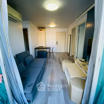 Modern living room with sleek furniture and stylish decor in a compact apartment setting.