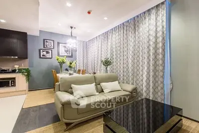 Modern living room with elegant decor and open dining area, featuring stylish furniture and ambient lighting.