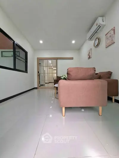Modern living room with sleek furniture and air conditioning, perfect for relaxation.