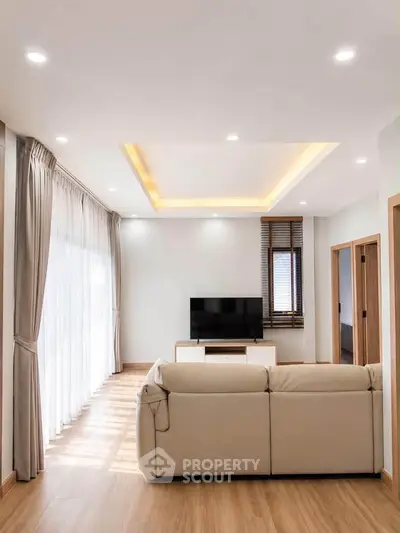 Spacious modern living room with elegant lighting and cozy seating area.