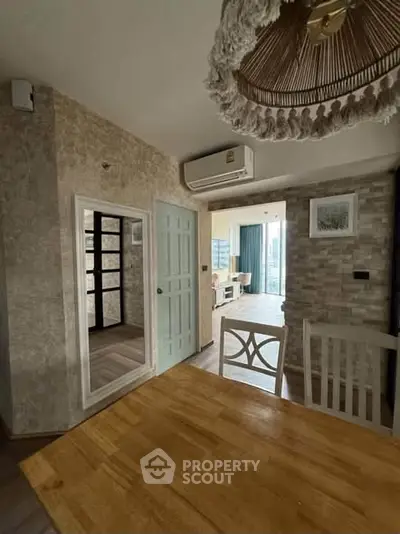 Charming dining area with rustic decor and air conditioning, leading to a bright living room with a view.