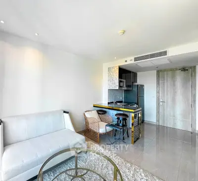 Modern living room with open kitchen, stylish furniture, and sleek design