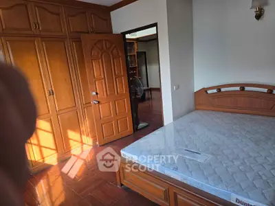 Spacious bedroom with wooden furniture and natural light