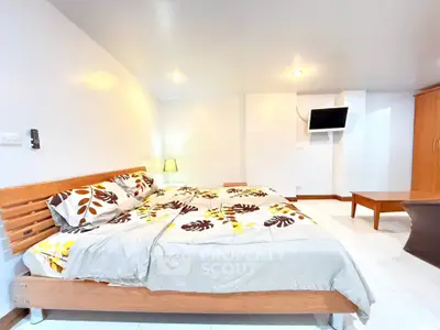 Spacious bedroom with modern decor and cozy lighting in a stylish apartment.