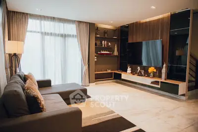 Luxurious living room with modern decor and large TV, perfect for relaxation.