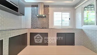 Modern kitchen with sleek cabinetry and stylish backsplash in a bright, airy space.