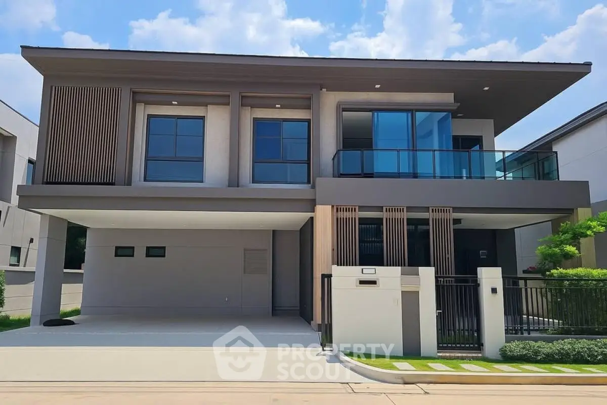 Modern two-story house with sleek design and large windows, featuring a spacious driveway and contemporary facade.