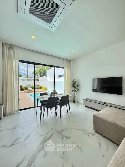 Modern living room with pool view, sleek furniture, and large sliding glass doors.