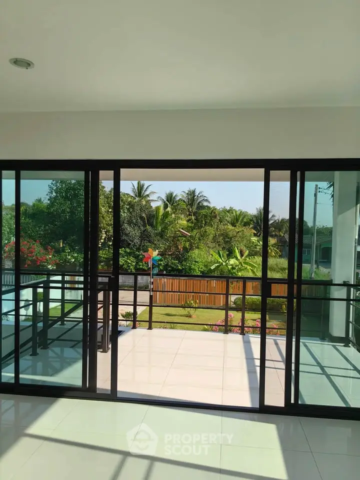 Spacious balcony with lush garden view and modern glass doors
